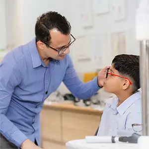 Optiker berät einen Jungen zur Brille.