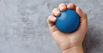 Hand mit einem blauen Ball