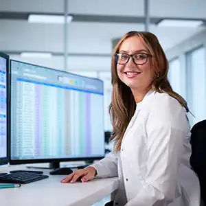 eine Pflegerin vor dem PC mit Patientendaten