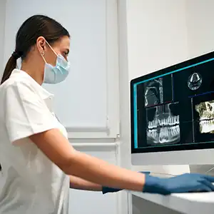 Zahnärztin am Computer mit digitalen Röntgenaufnahmen