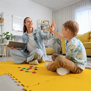 Logopäden und Junge beim Abklatschen