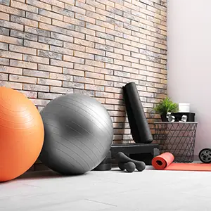 Inhaltsversicherung: Schutz für wertvolle Therapiegeräte Lichtdurchfluteter Raum mit großen Fenstern und Fitnesszubehör.