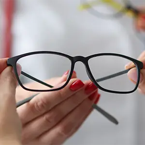 Moderne Brille wird von einem Optiker präsentiert.