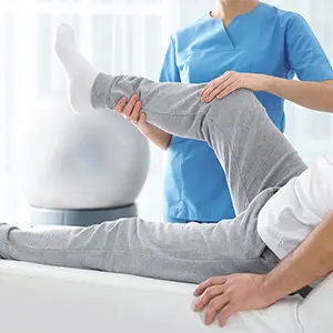 Rechtsschutzversicherung: Rechtliche Unterstützung bei Konflikten Physiotherapie Behandlung eines Beins durch einen Therapeuten.